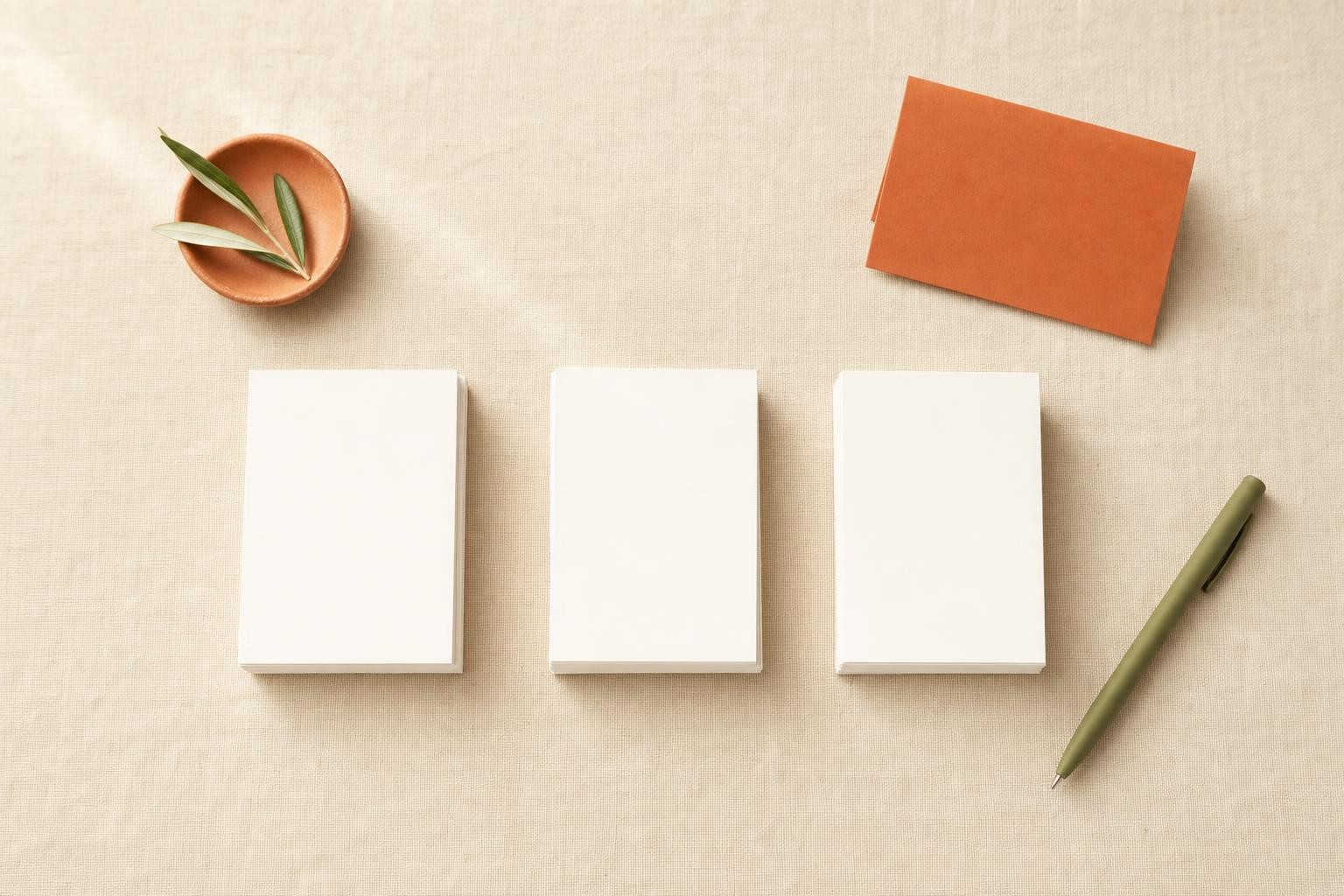 Three separate neat stacks of blank white cards on a linen surface, representing distinct content silos